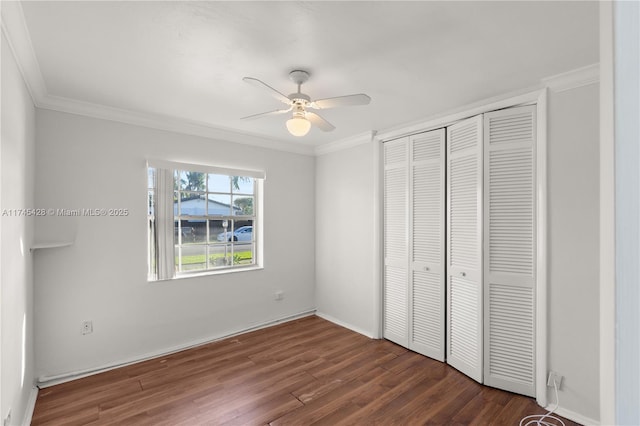 unfurnished bedroom featuring ornamental molding, dark hardwood / wood-style floors, ceiling fan, and a closet