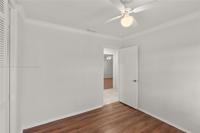 spare room with ceiling fan, ornamental molding, and wood-type flooring