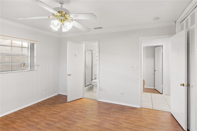 unfurnished bedroom with ceiling fan, ensuite bath, ornamental molding, and light wood-type flooring