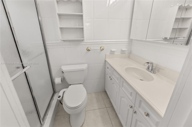 bathroom with toilet, a shower with shower door, tile walls, vanity, and tile patterned flooring