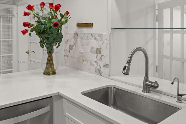 room details featuring white cabinetry, sink, backsplash, and dishwasher