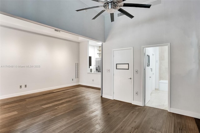 interior space with dark hardwood / wood-style flooring, ceiling fan, and a high ceiling