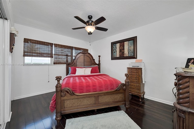 bedroom with dark hardwood / wood-style flooring, ceiling fan, and a textured ceiling