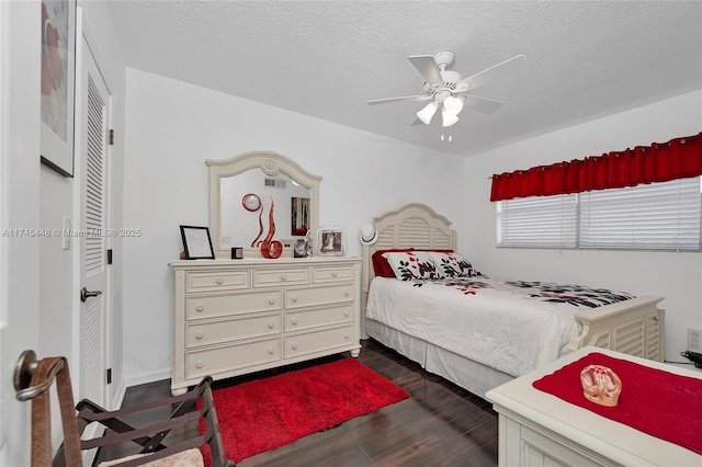 bedroom featuring dark hardwood / wood-style flooring, ceiling fan, and a textured ceiling