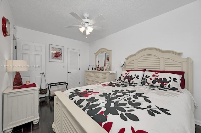 bedroom featuring ceiling fan, dark wood-type flooring, and a textured ceiling