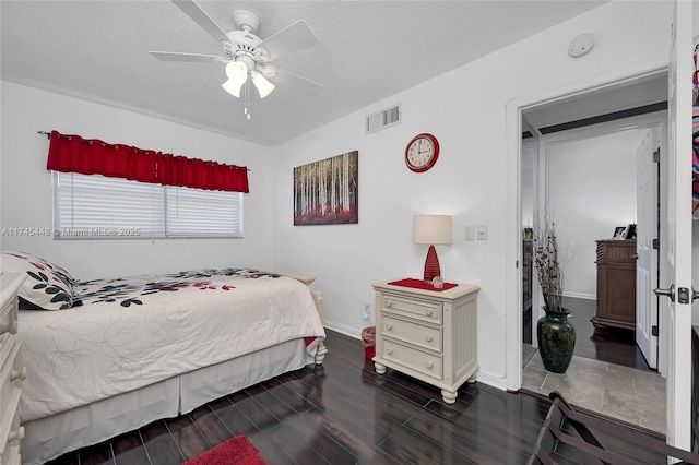 bedroom featuring dark wood-type flooring, a textured ceiling, and ceiling fan