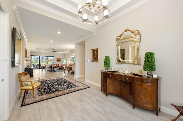 hallway featuring an inviting chandelier, baseboards, ornamental molding, and wood finished floors