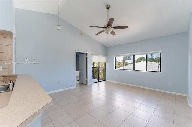 unfurnished room with light tile patterned floors, baseboards, ceiling fan, and a sink