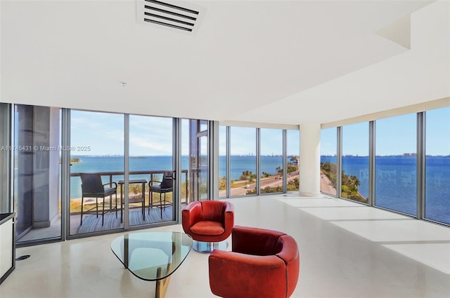 interior space with expansive windows, a water view, and concrete floors