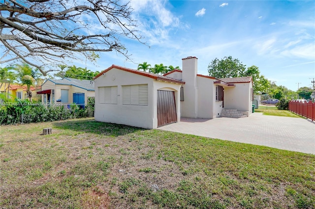 back of property with a yard and a patio