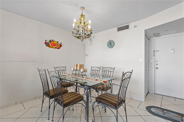 dining space featuring light tile patterned floors, a textured ceiling, and a chandelier