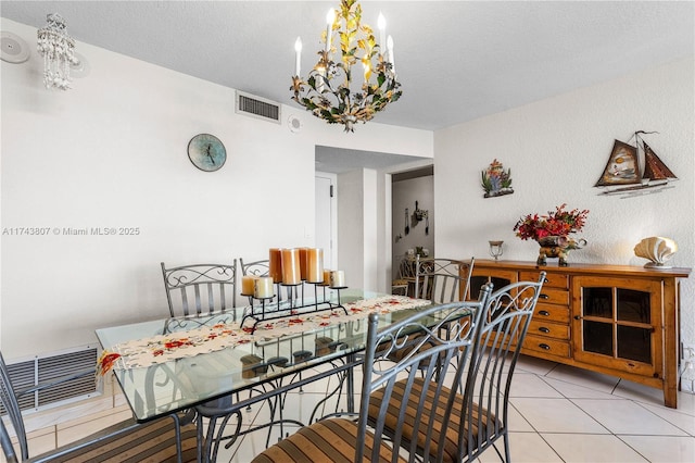 tiled dining area featuring a notable chandelier and a textured ceiling