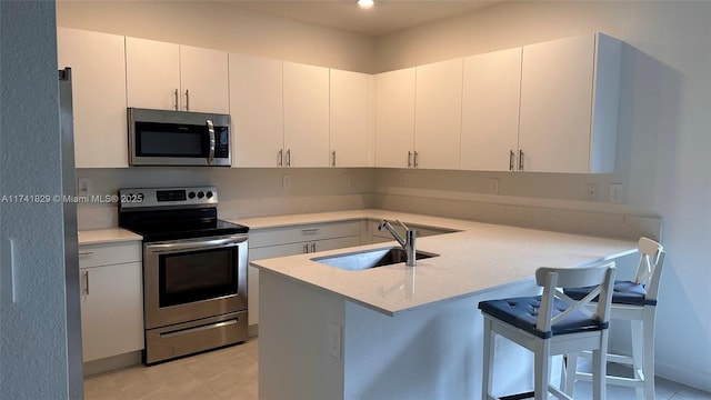 kitchen featuring white cabinetry, a breakfast bar area, stainless steel appliances, and kitchen peninsula