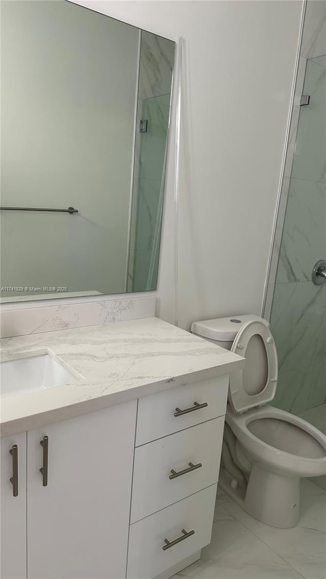 bathroom featuring vanity, an enclosed shower, and toilet