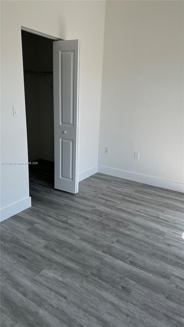 unfurnished bedroom featuring dark wood-type flooring and a closet