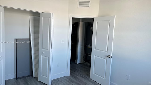 unfurnished bedroom featuring dark wood-type flooring and a closet