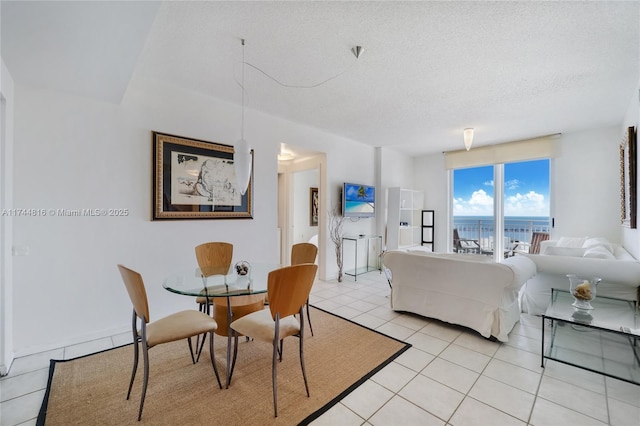 dining area featuring a textured ceiling and light tile patterned flooring