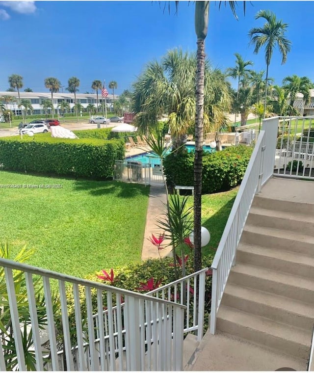 view of home's community with a pool and a lawn