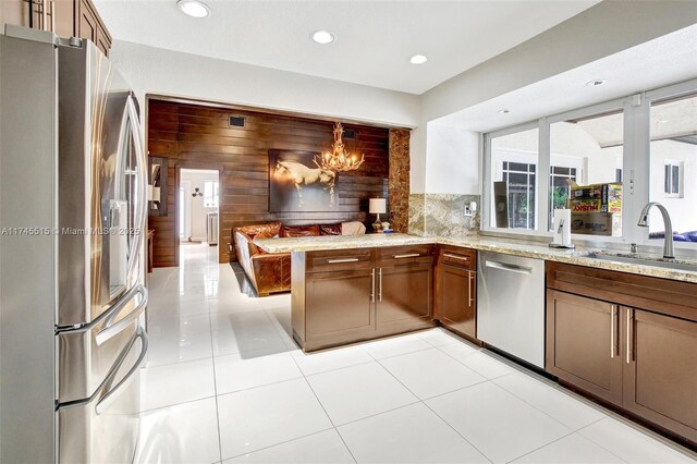 17500 SW 68th Ct, Southwest Ranches, FL 33331 - kitchen featuring stainless steel appliances, light stone counters, a sink, and a peninsula