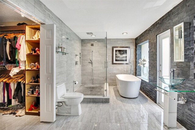 17500 SW 68th Ct, Southwest Ranches, FL 33331 - bathroom featuring a walk in closet, a freestanding bath, a stall shower, vanity, and toilet
