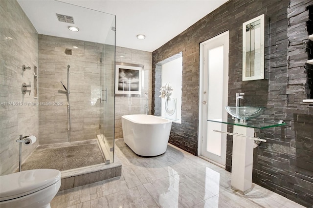 17500 SW 68th Ct, Southwest Ranches, FL 33331 - full bathroom with a sink, toilet, visible vents, a soaking tub, and a stall shower