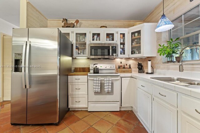 kitchen featuring backsplash, white cabinets, appliances with stainless steel finishes, and pendant lighting