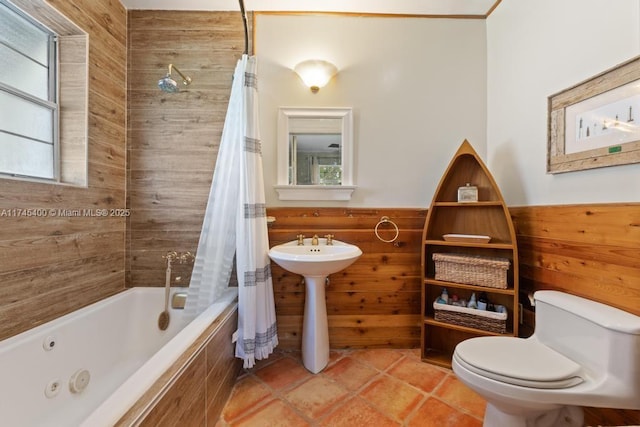 bathroom with toilet, plenty of natural light, wood walls, and wainscoting