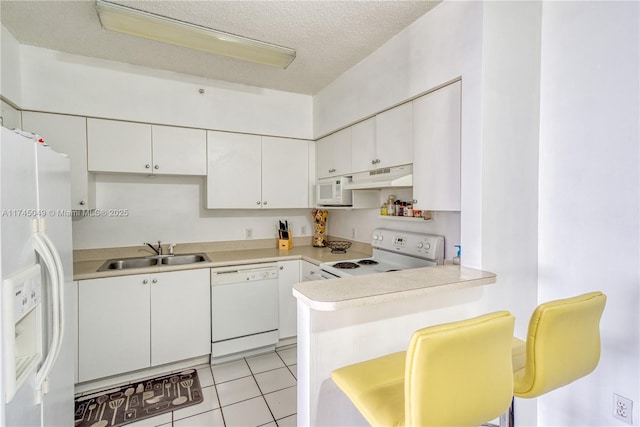 kitchen with white cabinetry, sink, white appliances, and kitchen peninsula