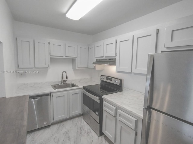 kitchen with light stone countertops, appliances with stainless steel finishes, and sink