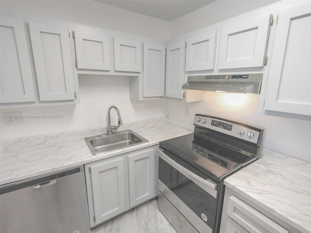 kitchen with stainless steel appliances, light stone countertops, sink, and white cabinets