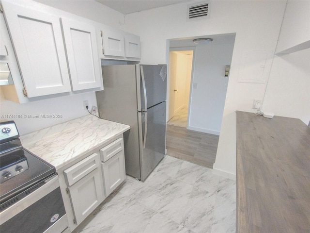 kitchen featuring stainless steel appliances and white cabinets