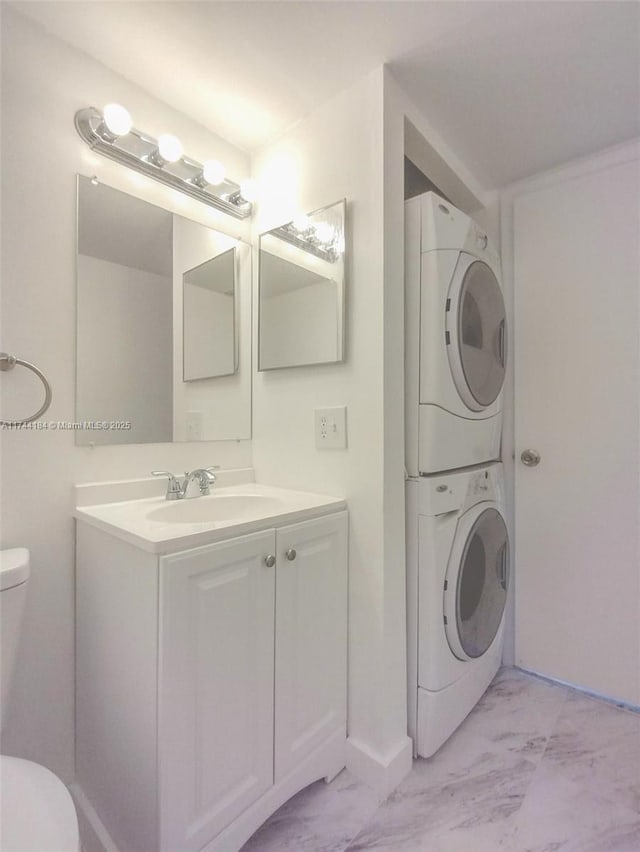 washroom featuring stacked washer / dryer and sink