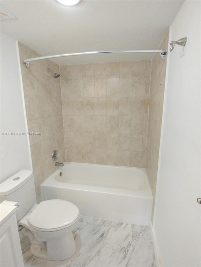 full bathroom featuring vanity, tiled shower / bath, and toilet