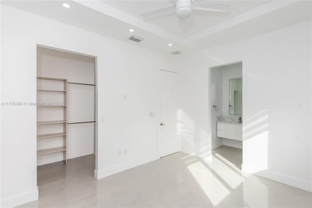 unfurnished bedroom featuring a walk in closet, ceiling fan, and a closet