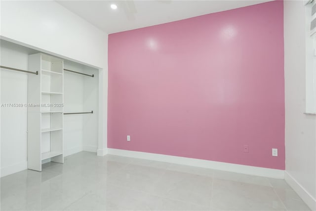 unfurnished bedroom with ceiling fan, a closet, and light tile patterned floors