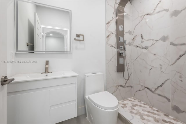 bathroom with vanity, toilet, and a tile shower