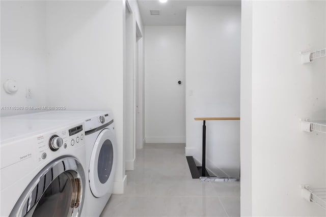 laundry area with light tile patterned flooring and washer and clothes dryer