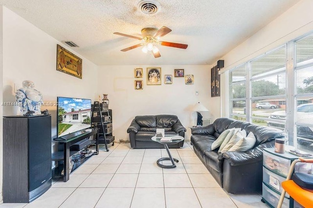 tiled living room featuring ceiling fan and a textured ceiling