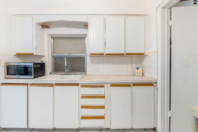 kitchen with white cabinetry, sink, and decorative backsplash