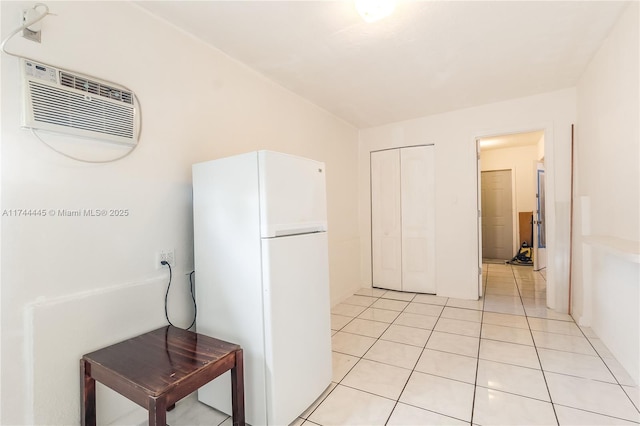 kitchen featuring light tile patterned floors, an AC wall unit, and white fridge