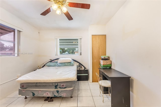 tiled bedroom with multiple windows and ceiling fan