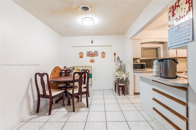 tiled dining room with a textured ceiling