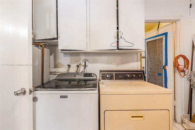 clothes washing area with cabinets and washer and dryer