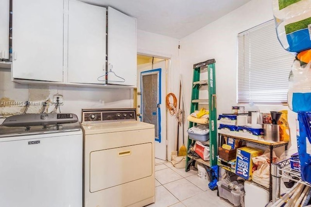 washroom featuring cabinets, washer and dryer, and light tile patterned flooring