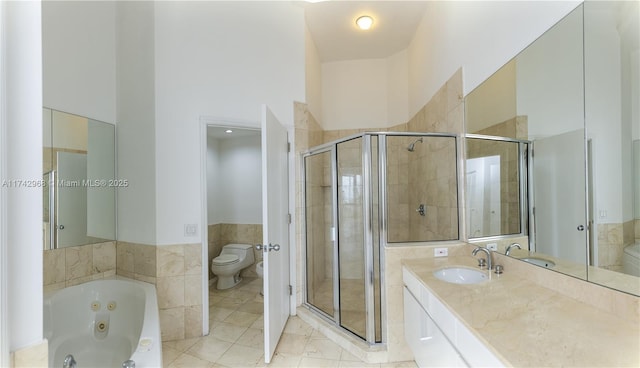 full bathroom with shower with separate bathtub, tile walls, vanity, and toilet