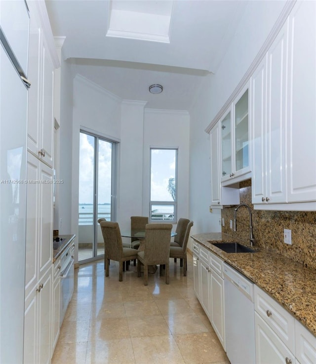 kitchen with white cabinetry, a water view, dark stone counters, and dishwasher