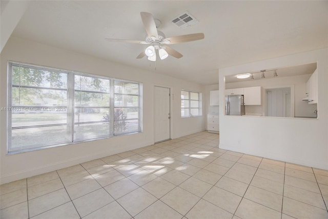 tiled spare room with ceiling fan