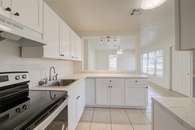 kitchen with sink, light tile patterned floors, electric range, white cabinets, and kitchen peninsula