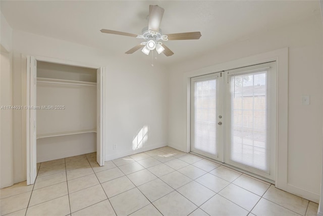 unfurnished bedroom with french doors, a closet, ceiling fan, and light tile patterned flooring