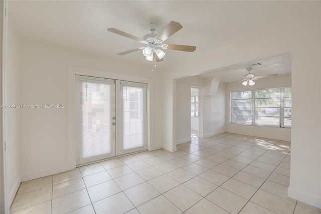 empty room featuring plenty of natural light, light tile patterned floors, and french doors